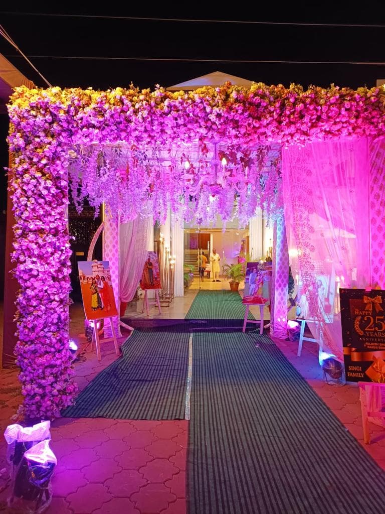 Floral entrance archway with pink lighting